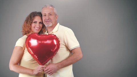 Mature couple in casual attire celebrating Valentine's Day, anniversary