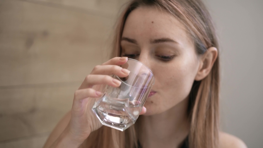 Attractive woman taking supplements pills and drink a glass of water Royalty-Free Stock Footage #1067234179