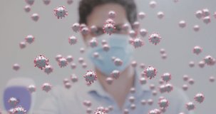 Animation of covid 19 cells floating over man wearing face mask holding digital thermometer. Healthcare and protection during coronavirus covid 19 pandemic, digitally generated video.