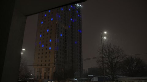 Night illuminated apartments building winter snow on the street