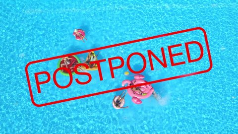 AERIAL, TOP DOWN: Large red postponed sign covers a group of carefree tourists partying in a pool as all upcoming events are cancelled until further notice because of the global coronavirus pandemic.