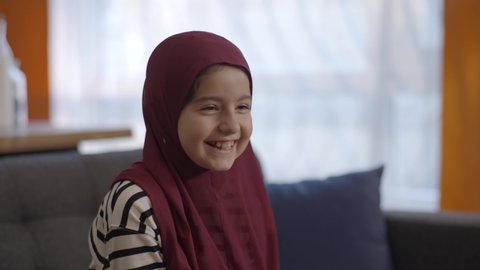 Muslim girl in a little turban laughing big with happiness. Muslim girl in a little turban laughing very much.