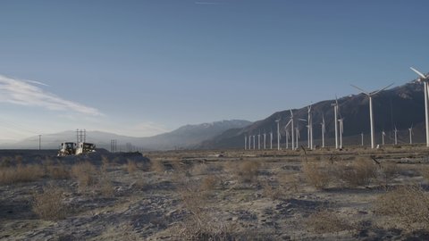 Wind turbines and construction vehicles in the desert