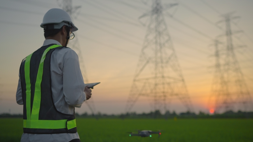 An electrical engineer forcing a drone To inspect high voltage poles before starting a project Assigned by the organization during the sunset time
 Royalty-Free Stock Footage #1067256427
