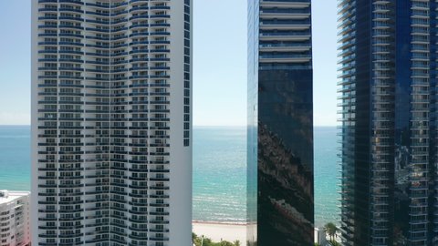 Modern architecture skyscrapers in Miami beach, aerial view. Contemporary glass apartment buildings with ocean view, drone b roll footage. Cinematic prestige residential area 4K. Luxury lifestyle shot