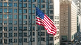 Patriotic aerial of vibrant flag of United States of America flattering with modern building on background in financial district in downtown Miami, Florida USA. President and Independence day drone 4K - Powered by Shutterstock - Get 15% off with code: PIKWIZARD15