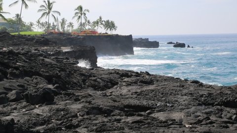 Kona, Hawaii - October 30 2013: Waves crashing on volcanic rocks at the Sheraton Kona Resort and Spa Hotel