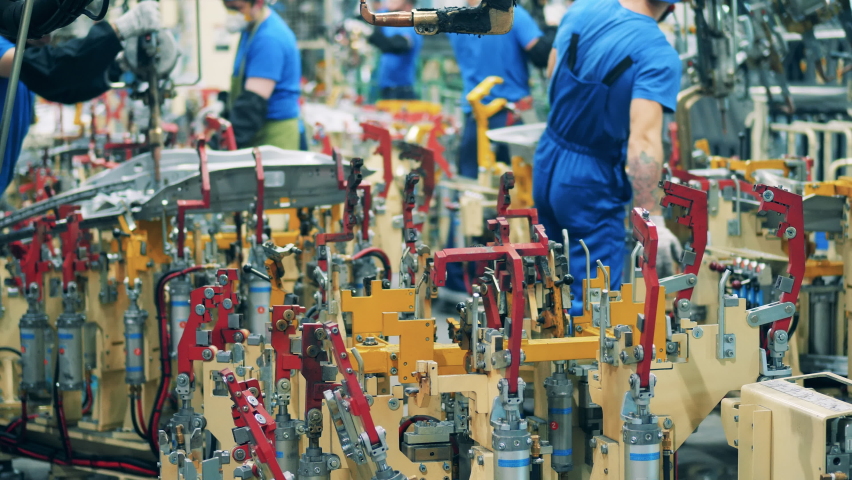 Automobile factory unit with mechanics assembling and welding car parts