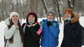 Four teenage friends take off their medical masks outdoors in winter and smile happily as they celebrate the end of the Covid-19 pandemic - Powered by Shutterstock - Get 15% off with code: PIKWIZARD15