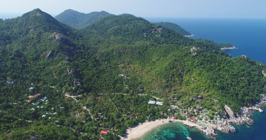Thailand's island aerial: mountains, jungle at ocean bay. Mesmerizing Thai landscape with green hills and white sand beach of Koh Tao isle, Tanote Gulf. Dramatic footage shot in 4K, UHD Royalty-Free Stock Footage #1067285353