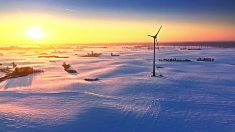Snowy field and wind turbine at sunrise, whiteout in winter, Poland