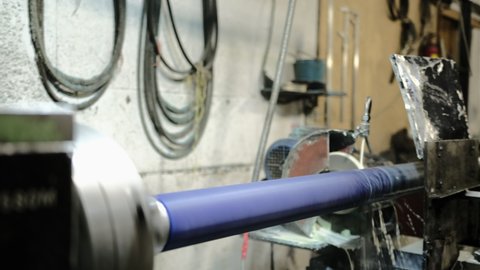 Blue roller grinding. Emulsion grinding of a polyurethane shaft on a lathe. Shaft grinding with polyurethane, rubber, silicone coating. Grinding roller
