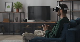 adult man is playing modern computer game, using head-mounted display and joystick, virtual reality technology for fun