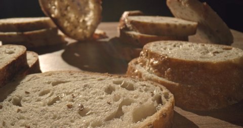 Natural bread is on the kitchen table. Sliced ​​slices of freshly baked black vegetarian bread bread stand in a beautiful composition. Cinematic slow 4K video.
