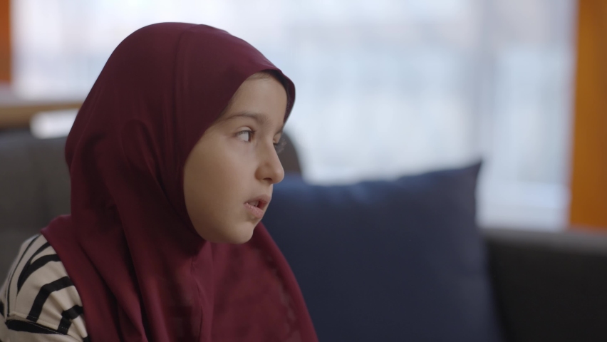 Muslim little girl with a turban, bored and sad. Thoughtful, bored, sullen little turban girl. | Shutterstock HD Video #1067306485