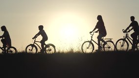 Silhouettes of a large large family on bicycles at sunset. - Powered by Shutterstock - Get 15% off with code: PIKWIZARD15