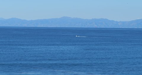 A fast powerboat moving through the Pacific Ocean on a summer day