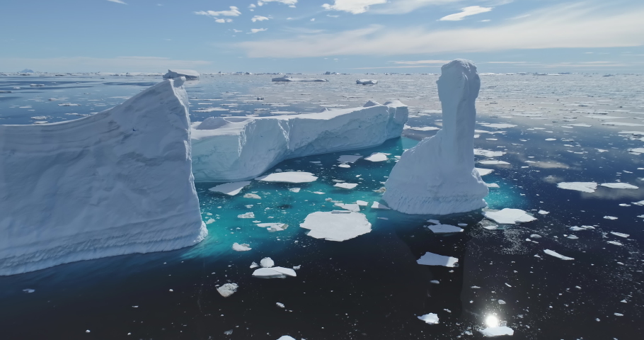 Global issue of climate change and melting icebergs on South Pole aerial. Uninhabited Antarctica environment and nature scape of seas and land in snow and ice at sun winter day. Warming clime Royalty-Free Stock Footage #1067310868