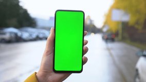 Handheld Camera: Point of View of Woman at street Using Phone With Green Mock-up Screen Chroma Key Surfing Internet Watching Content Videos Blogs