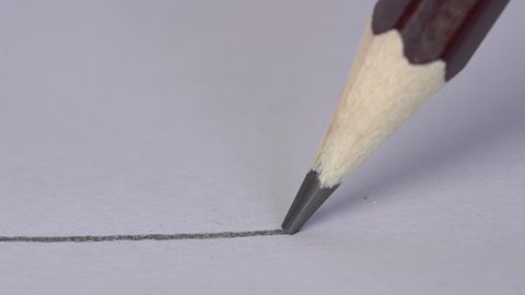 Artist hand drawing a flat gray line with a graphite wooden pencil on white paper. Close up, macro, 4k