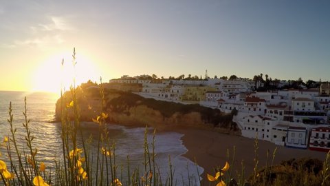 Dreamy sunset on cliffed coastlines in Carvoeiro, Portugal. With lots of housing in the distance.