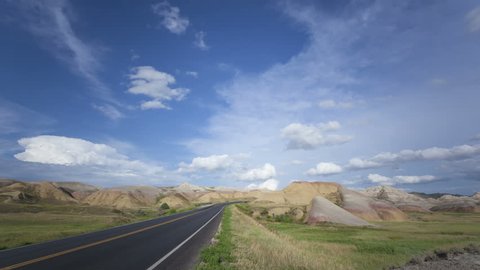4K Time lapse zoom in Badlands Loop Road through the colorful Yellow Mounds area with clouds passing by a blue sky at Badlands National Park in South Dakota
