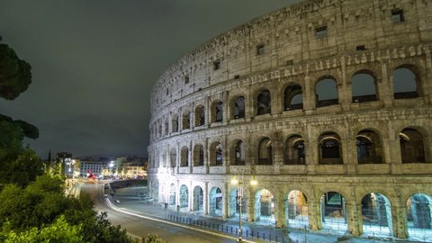 Colosseum illuminated at night timelapse hyperlapse in Rome, Italy. Top view. Traffic on the road