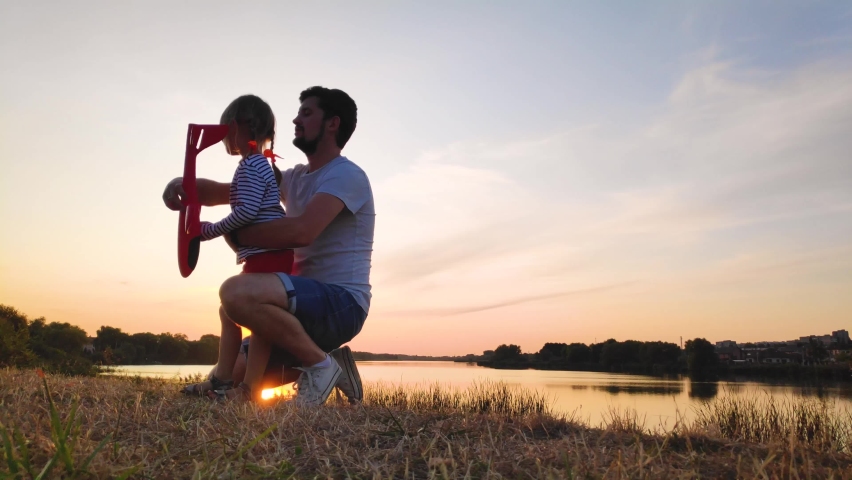 Father and daughter play fun at sunset