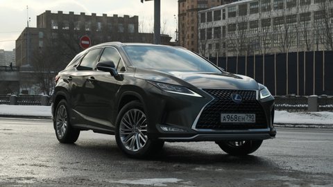 Moscow, Russia - CIRCA 2020: Lexus RX green SUV stay on road. Nice slow dolly footage in city.
