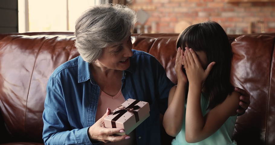 Caring grandma makes surprise on birthday 10s granddaughter give her present box, happy girl feel grateful hugs older granny. Life event celebrations and holiday congrats moment, gift store ad concept Royalty-Free Stock Footage #1067349796