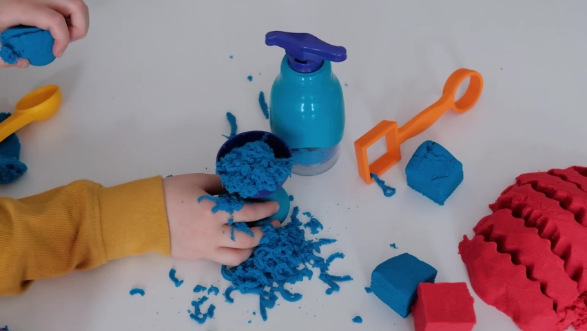 Close up of childrens hands playing with kinetic sand