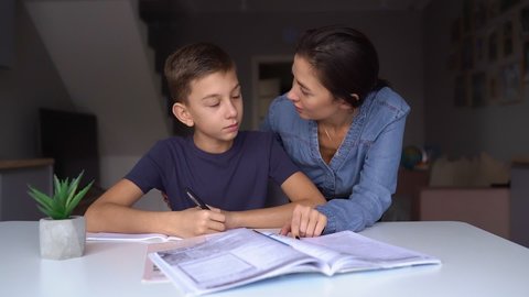 Mom and adult son teach homework at home, mom helps son do homework, sister helps teach lessons to teenager, study at home, beautiful mom and handsome adult son study at home