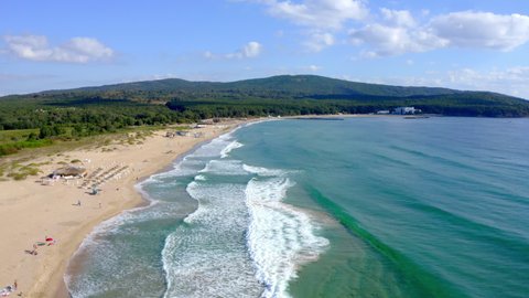 Aerial footage of the Bulgarian Black sea in Primorsko showing a drone top down view of a beautiful sandy beach with beach parasols