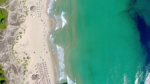 Aerial footage of the Bulgarian Black sea in Primorsko showing a drone top down view of a beautiful sandy beach with beach parasols