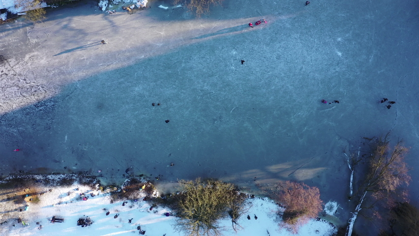 Aerial shot of children and ice skaters on a frozen pond in the park.  Amsterdam, Netherlands.