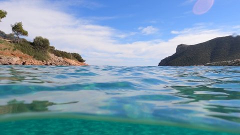 Underwater split video from famous calm sea beach of Avlaki, Porto Rafti, Mesogeia, Attica, Greece
