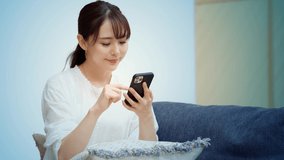 Young asian woman watching videos with a smart phone. Digital conctents.