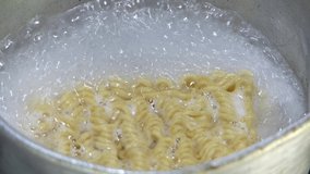 Instant noodles in boiling water in an aluminum pot