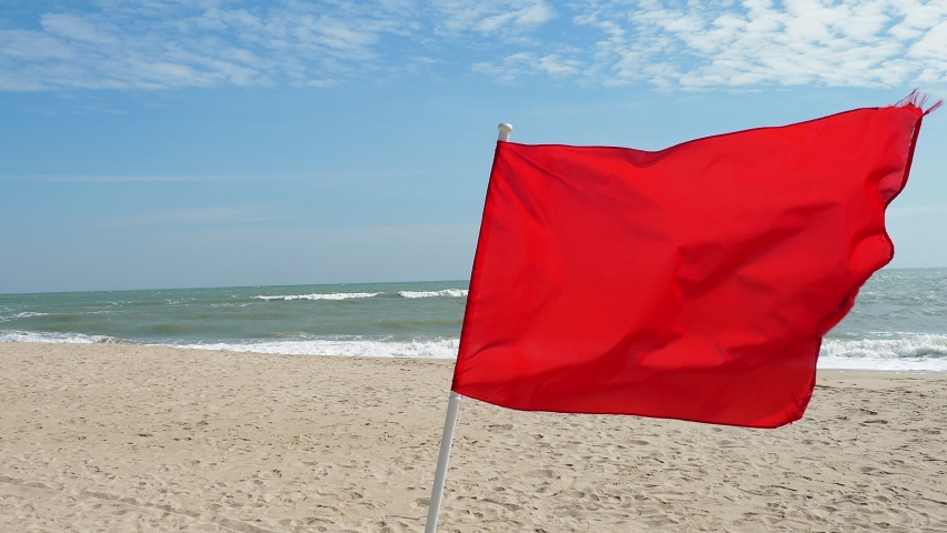 The red flag on the beach is a warning sign that tourists are prohibited from playing in the sea on strong waves , focus on clarity of flagpole Royalty-Free Stock Footage #1067382419