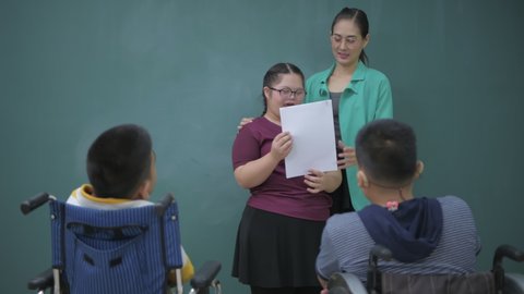 Education concept of 4k Resolution. Children with disabilities present to their friends in front of the class.