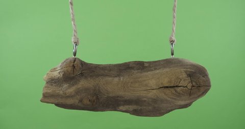 An old sign made from a board, swinging suspended from ropes. Isolated on green screen.