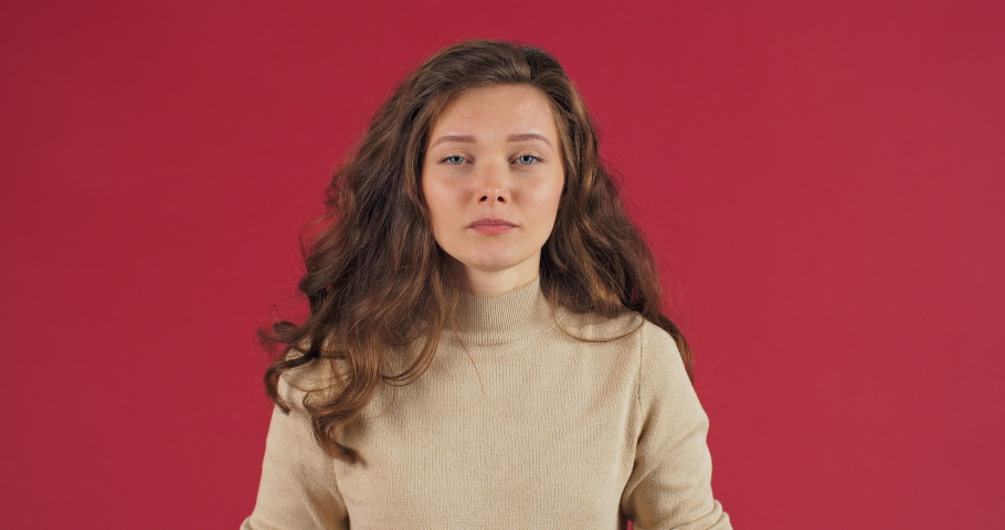 Close-up annoyed irritated young caucasian woman with angry face looking furious mad opens his mouth shouts loudly from stress feeling frustrated isolated on red studio background. Female expression Royalty-Free Stock Footage #1067396411