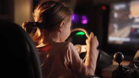 a little girl plays computer games, a child plays a racing game on a car simulator. concept of video games The newest gadgets