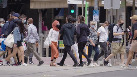 Melbourne, Australia - Jan 12, 2021: Slow motion video of pedestrians walking on the street in Melbourne, many are wearing face mask due to coronavirus pandemic