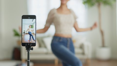 Asian young woman created her dancing video by smartphone camera. To share video to social media on TikTok application.