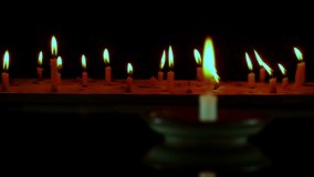 Candles flame on old wooden table  on dark Background.
