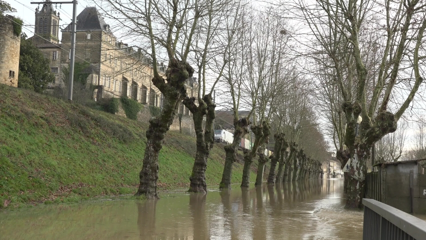 A freight train passes through a village whose streets are flooded