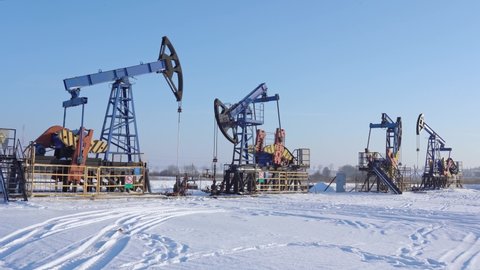 Oil and gas industry. Working oil pump jack on a oil field at winter sunny day. Oil production in Siberia