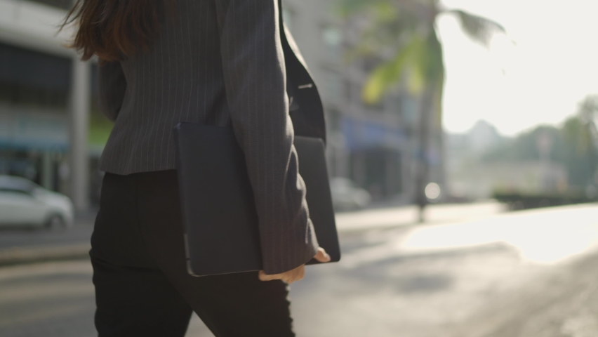 close-up Video Slow-motion. A white business Asian woman in a black suit walking on the street side. Carrying a laptop to work at the office in the morning.
 Royalty-Free Stock Footage #1067426642