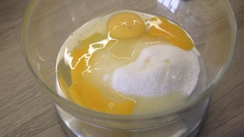 Sugar. Raw Egg Yolks. Cooking Dessert. Cooking. Into Transparent Bowl Woman Breaks Egg. Close-up. Food. Pamper the Family. Cook at Home. Yellow. Sweet Dessert. Whisk Mix with Mixer. Cooking Macarons